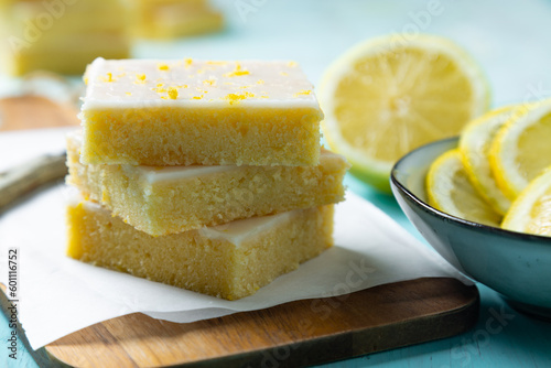 Homemade lemon brownies with lemon glaze and zest on a cutting board