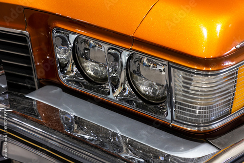 Tableau sur toile Close-up of the round headlamps of a orange american classic car