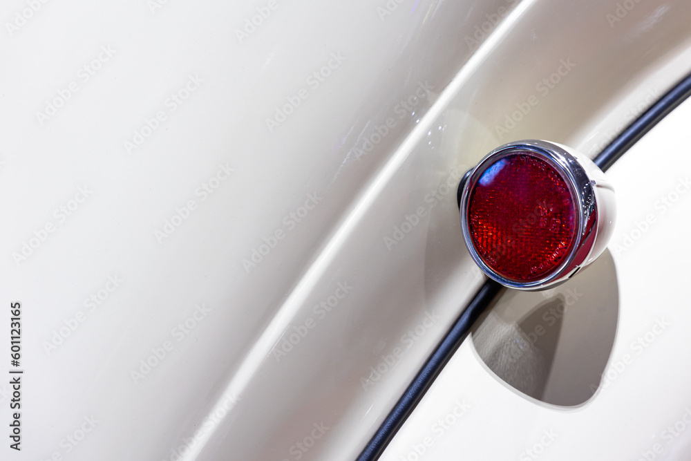 Close-up of the tale lights of a white classic car. Beautifully restored chrome details of a historic vehicle.