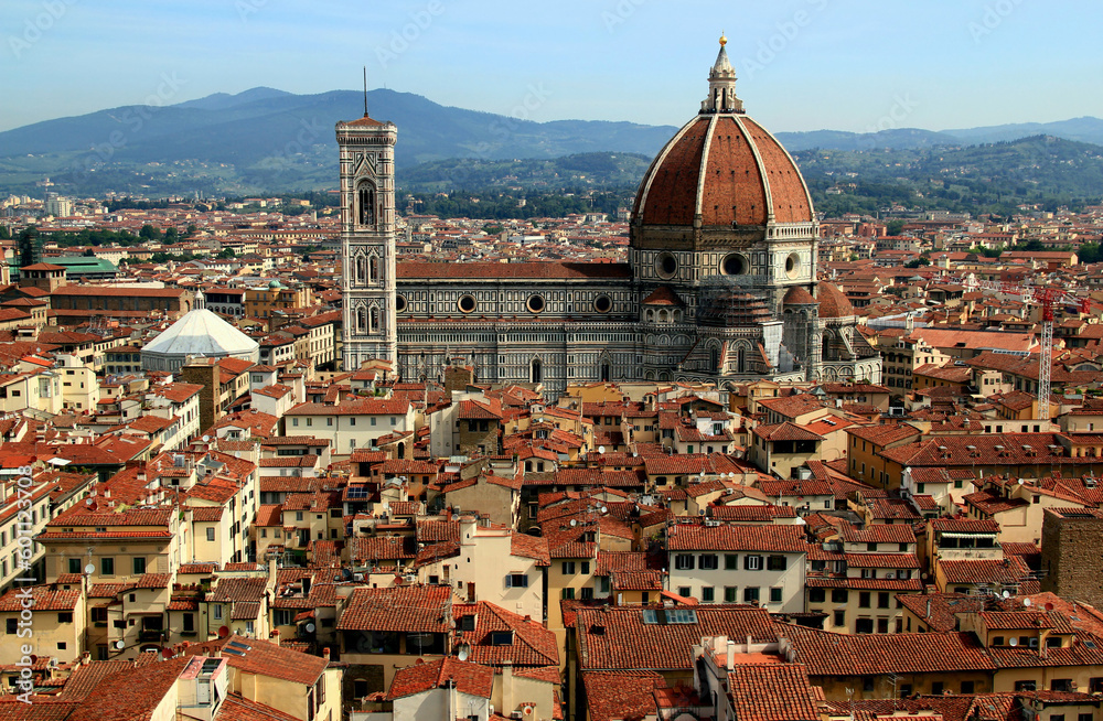 Panoramic view of the historic part of the city of Florence (Italy) with the Cathedral Cattedrale di Santa Maria del Fiore in the center of the photo against the background of the mountains