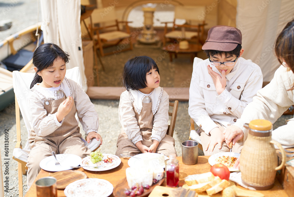 キャンプで食事を楽しむ子供たちと親 キャンプで食事を楽しむ子供たちと親