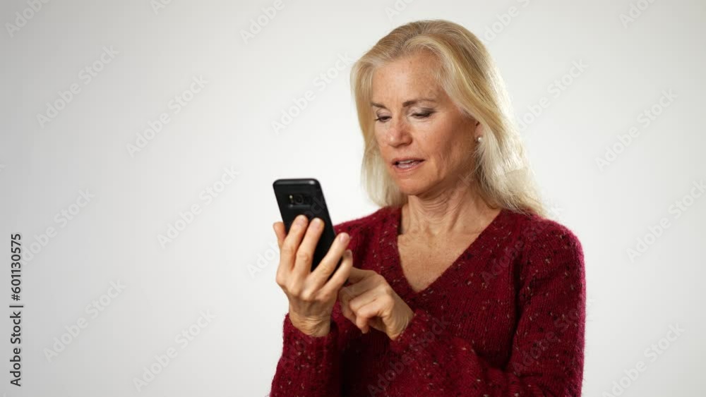 Fit healthy mature senior woman 50s, 60s, takes a selfie with a phone camera smartphone, isolated on white background. Fit healthy mature senior woman 50s, 60s, takes a selfie with a phone camera smartphone, isolated on white background.
