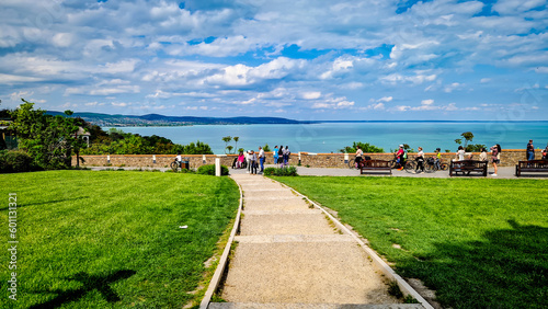 Cyclists and tourists on the promenade enjoying the view of clear water of Lake Balaton. Tihany, Hungary