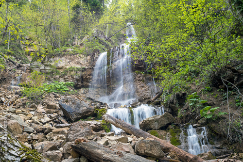 Beautiful mountain waterfall in the forest in spring. Waterfall in the forest. Beautiful nature and relaxation.