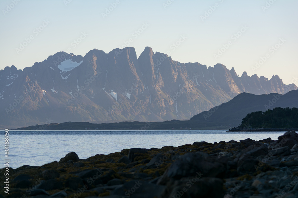 Rocky shore with mountains in the background on the shore of a fjord in northern Norway