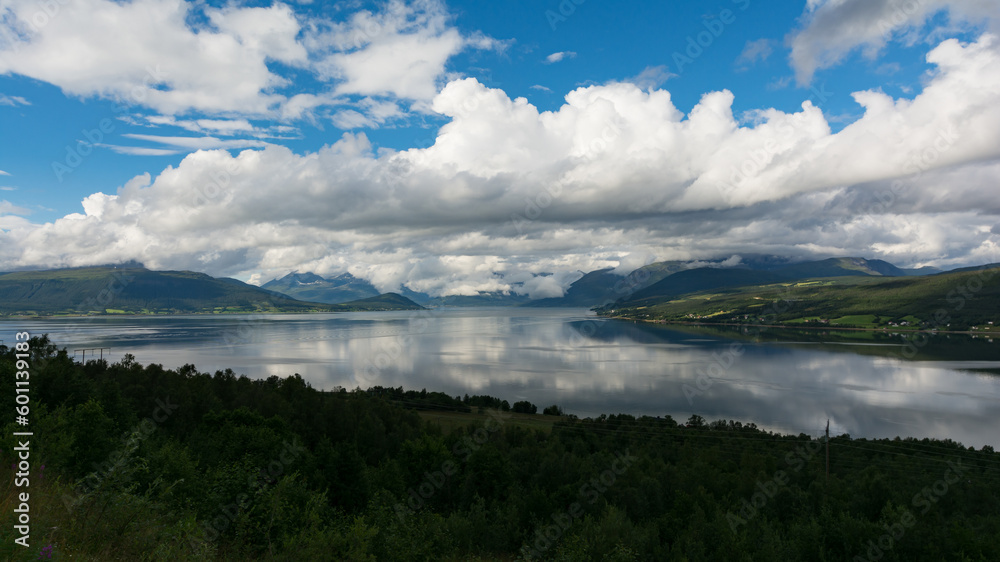 Blue skies and white clouds over a fjord landscape in northern Norway