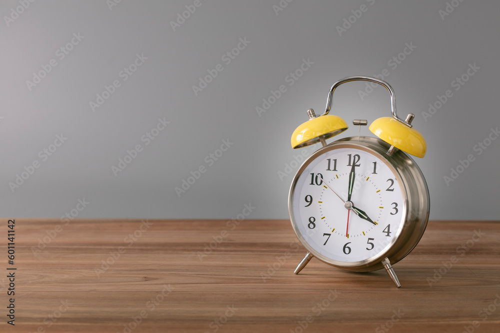 Retro silver alarm clock. 4:00. am, pm. Neutral background. Brown wood surface. Horizontal photography with empty space for text or image. Retro silver alarm clock. 4:00. am, pm. Neutral background. Brown wood surface. Horizontal photography with empty space for text or image.