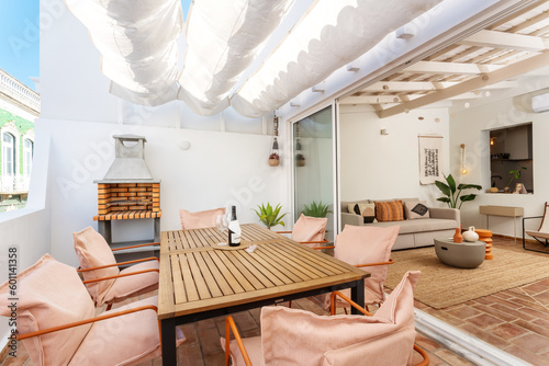 Balcony terrace with barbecue picnic overlooking the living room inside. Modern apartment.