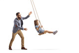 Father pushing a little girl on a swing