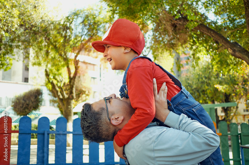 father playing and carrying his son in an outdoor park with mario bros clothes in the city of la paz, bolivia