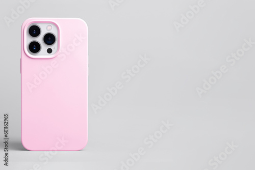 pink phone case mockup, iPhone 14 pro mock up back view isolated on grey background, banner with place for text on the right