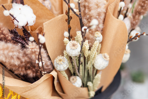 A bouquet of cotton flowers with a brown paper wrapper.