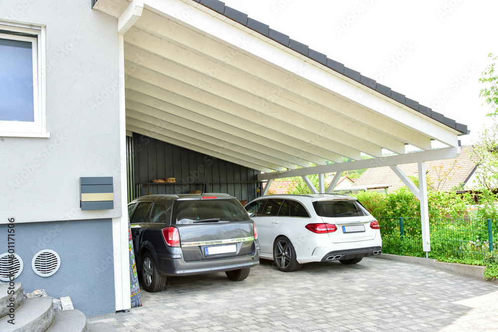 Moderner Carport aus lasiertem/lackiertem Holz im Einfahrtsbereich eines Wohnhauses