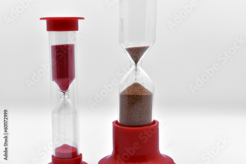 Glass hourglass on a white background. Multicolored glass hourglass.