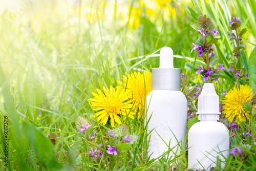 Concept of seasonal spring and summer allergy. Antihistaminic preparations in medicine bottles on flowering nature background with copy space photo