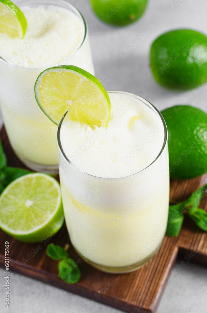 Brazilian Lemonade, Refreshing Creamy Lemonade or Limeade with Lime Slices and Mint on Grey Background Brazilian Lemonade, Refreshing Creamy Lemonade or Limeade with Lime Slices and Mint on Grey Background