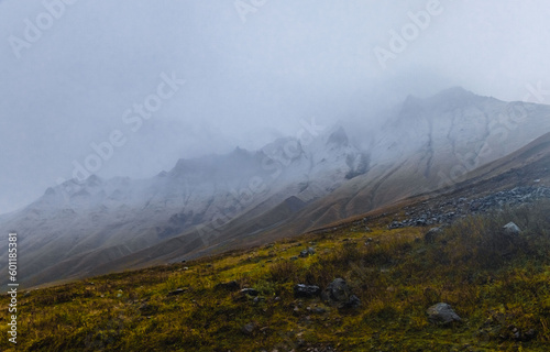 Clouds cover slopes of Kazbegi mountain in Georgia Caucasus photo