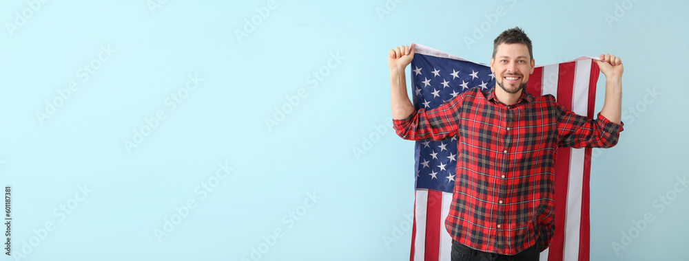 Handsome man with USA flag on light blue background with space for text