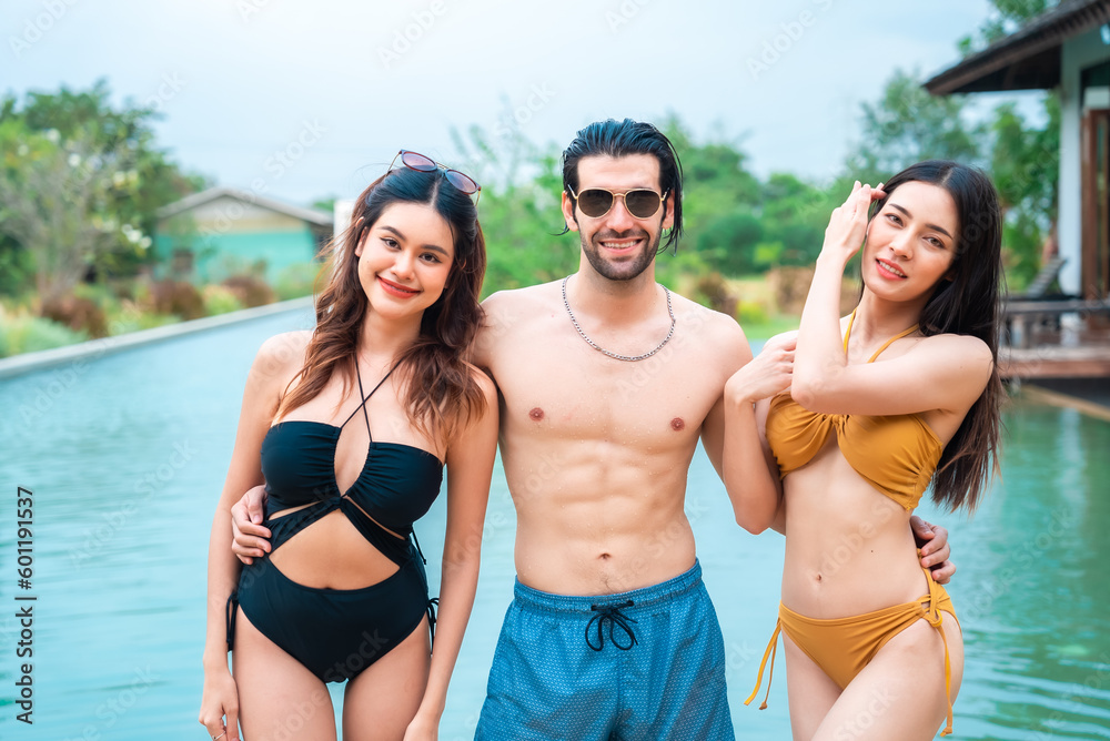 portrait of young Asian woman person wearing bikini swimwear having relax at swimming pool in summer vacation lifestyle, sexy female pretty happy to travel and living fun in luxury outdoor resort