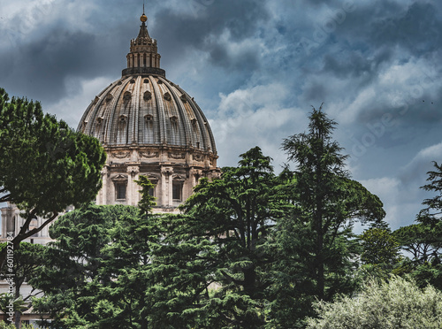 Imponująca kopuła Bazyliki Świętego Piotra w Rzymie, widziana z perspektywy Muzeum Watykańskiego. Masywne i majestatyczne struktury są symbolem historycznej i religijnej potęgi Watykanu.