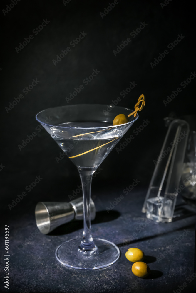 Glass of tasty martini and measure cup on dark background Glass of tasty martini and measure cup on dark background