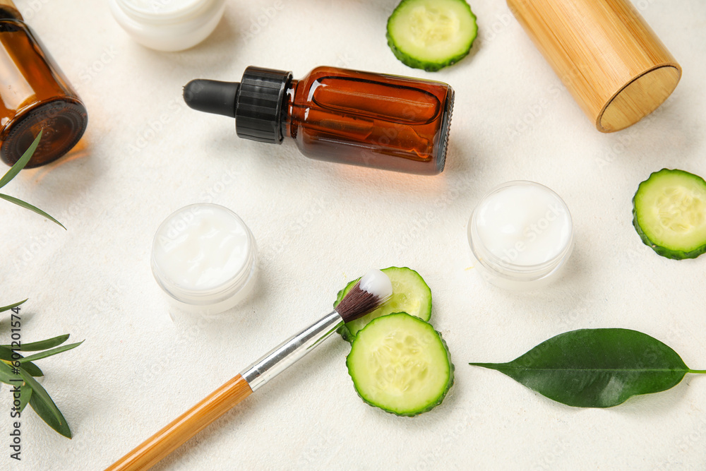 Composition with natural cosmetic products, cucumber slices and brush on light background