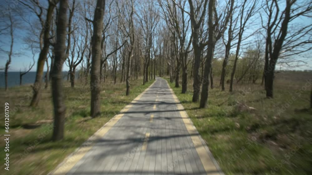 Man riding bicycle along bike path on seashore. POV shot Man riding bicycle along bike path on seashore. POV shot