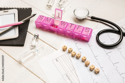 Word HORMONES with medical supplies on white wooden background, closeup