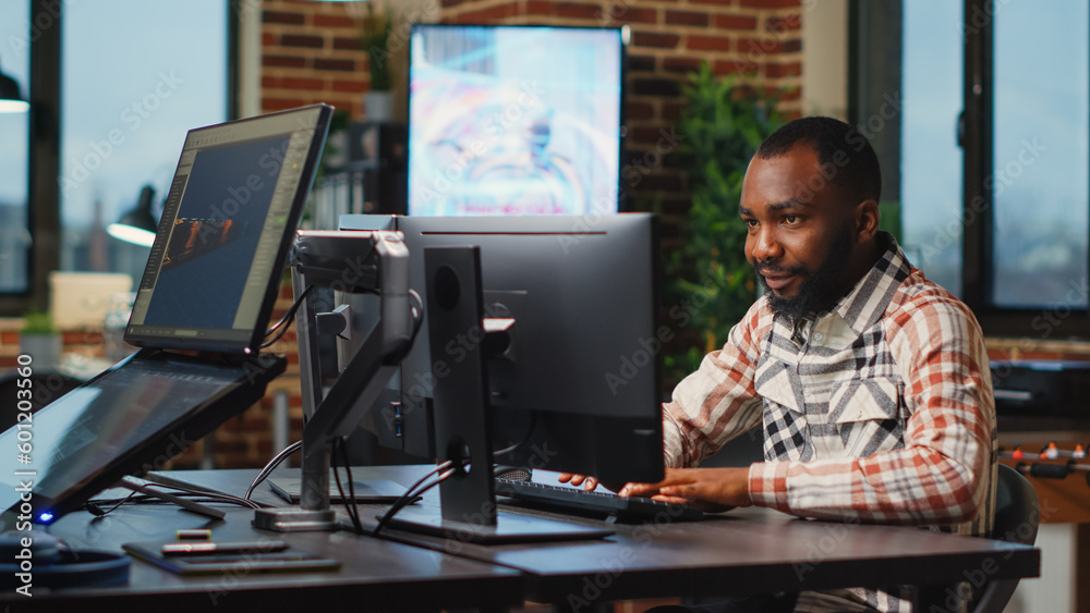 African american male artist working in studio office to create CGI production on software, digital skills. Creative agency designer using professional interface to develop infographics. African american male artist working in studio office to create CGI production on software, digital skills. Creative agency designer using professional interface to develop infographics.