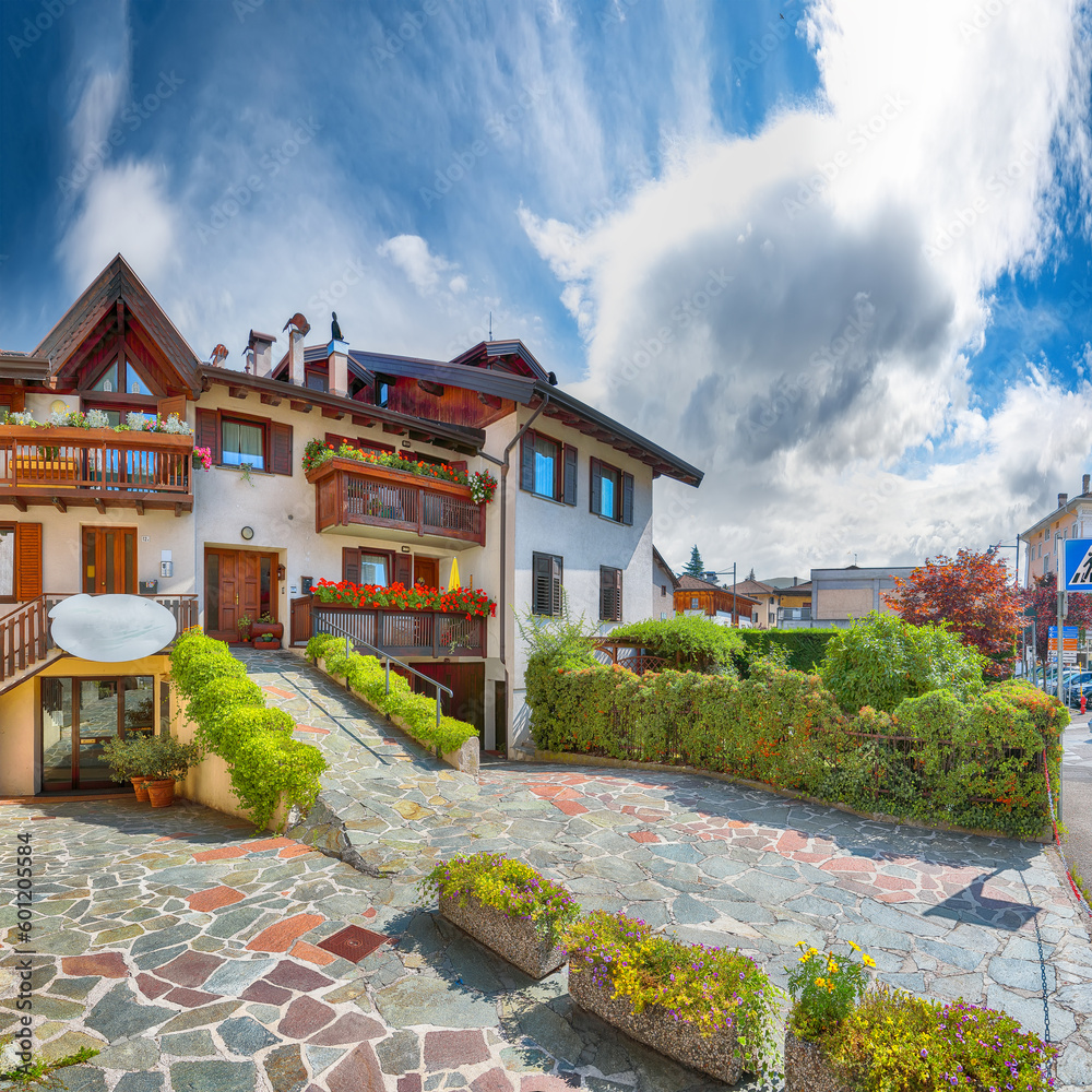 Awesome View of Traditional alpine houses with flowers on balcony the Cles city.