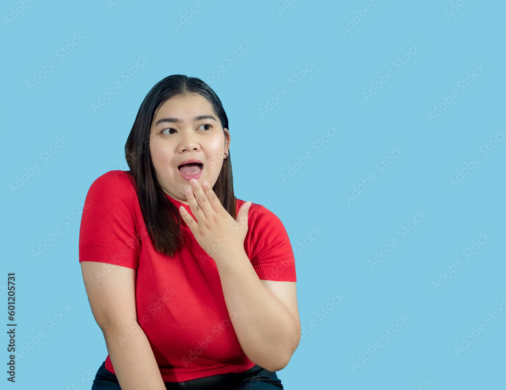 Portrait girl young woman asian chubby fat cute beautiful pretty one person wearing a red shirt is sitting smiling enjoy happily looking wow to copyspace imaginary on the blue background Portrait girl young woman asian chubby fat cute beautiful pretty one person wearing a red shirt is sitting smiling enjoy happily looking wow to copyspace imaginary on the blue background