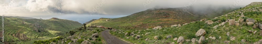 Huge panorama landscape of beautiful sunset over road on countryside full of mountains, green fresh grass, rocks and ocean in tenerife, canarias, spain Huge panorama landscape of beautiful sunset over road on countryside full of mountains, green fresh grass, rocks and ocean in tenerife, canarias, spain