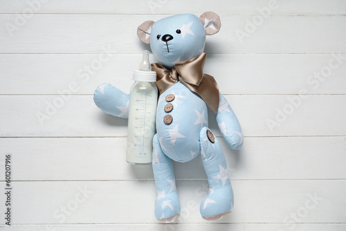 Teddy bear with bottle of m...