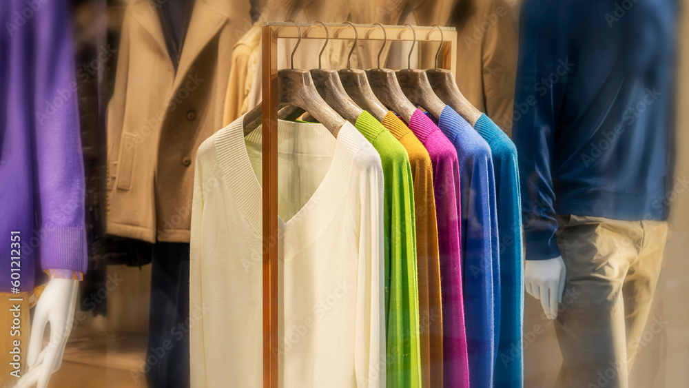 Fototapeta premium Multicolored pullovers, clothes on hanger in store, selective focus. Shopping