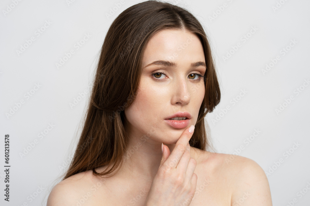 Closeup beauty portrait of caucasian dark-haired woman holding hands on her face Closeup beauty portrait of caucasian dark-haired woman holding hands on her face