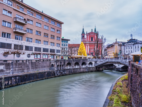 winding Ljubljana River, colorful The Franciscan Church of the Annunciation houses and baroque buildings on the river bank, Slovenia