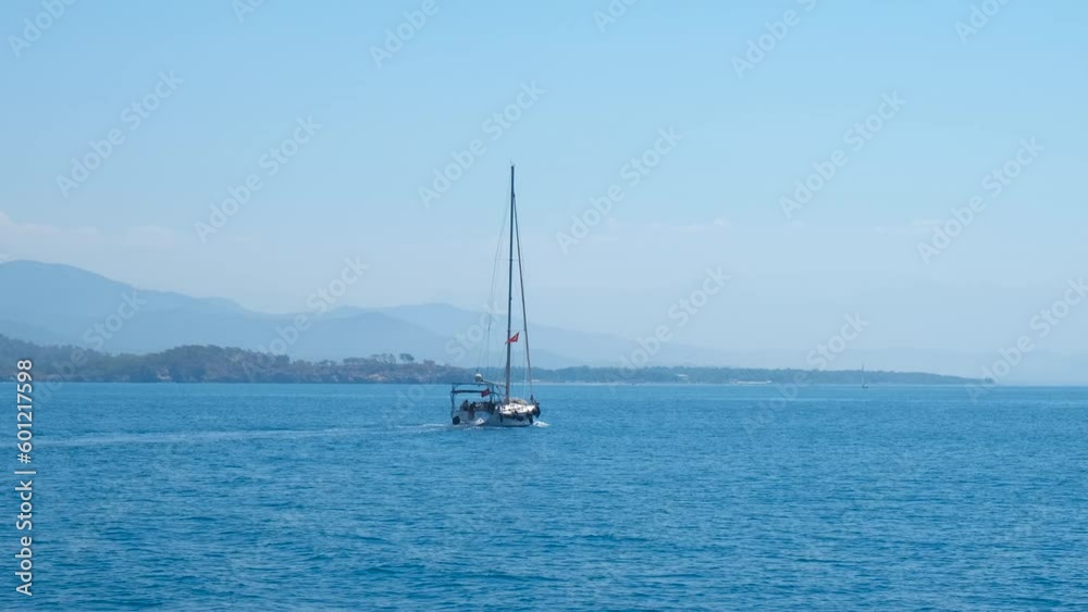 Sailing ship swinging in lagoon. A view of motor yacht sailing in the blue ocean in tropical lagoon during sunny day. A concept of amazing sea view in summer. Sailing ship swinging in lagoon. A view of motor yacht sailing in the blue ocean in tropical lagoon during sunny day. A concept of amazing sea view in summer.