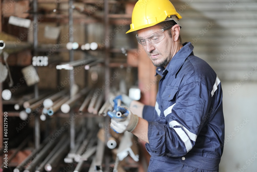 Male technician programs a robot arm with a digital tablet and assembly robot in a factory. Apprentice engineers programming robots in factory. Male technician programs a robot arm with a digital tablet and assembly robot in a factory. Apprentice engineers programming robots in factory.