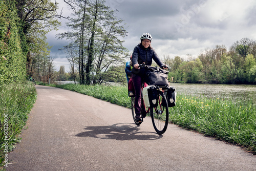 Exploration en vélo d'une jeune maman et fille le long du canal sous un ciel lumineux