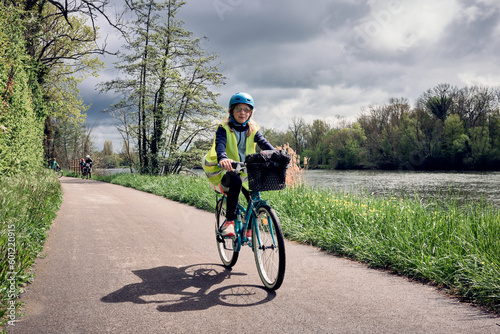 Exploration en vélo d'une jeune fille de 10 ans le long du canal sous un ciel lumineux
