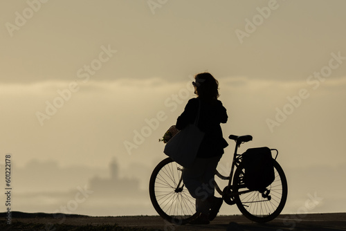 Fototapeta Naklejka Na Ścianę i Meble -  Silhouette of a woman with a bicycle at sunset