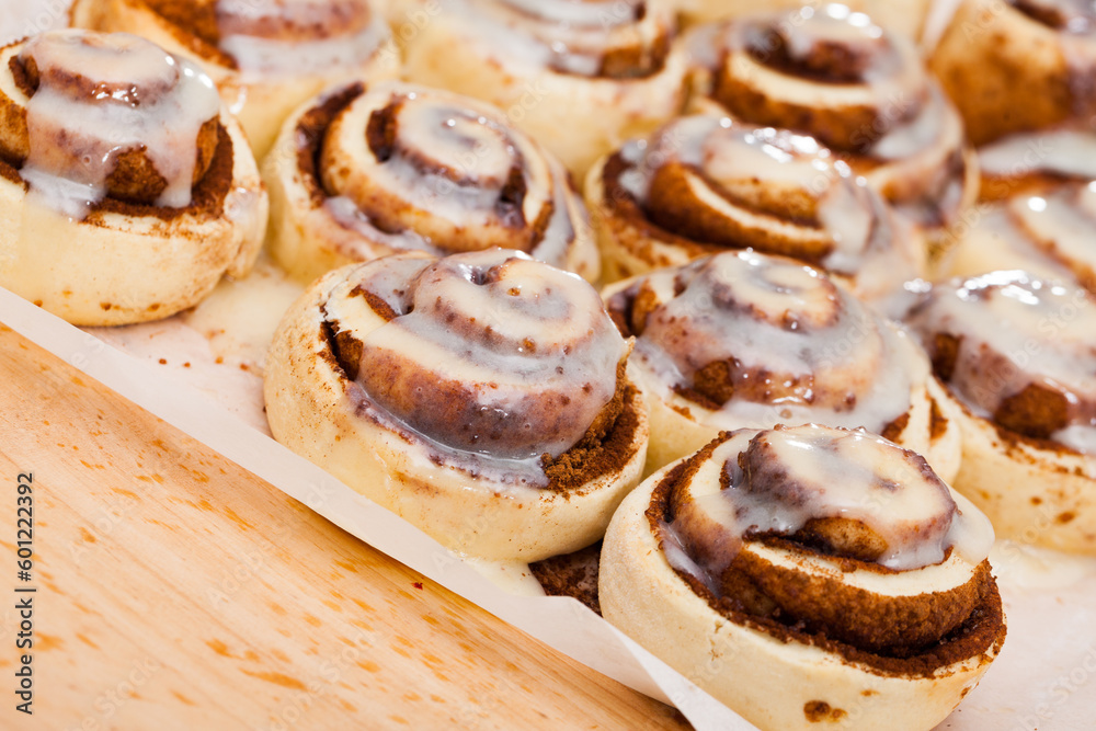 Classic cinnamon rolls cinnabons with creamy frosting on baking paper