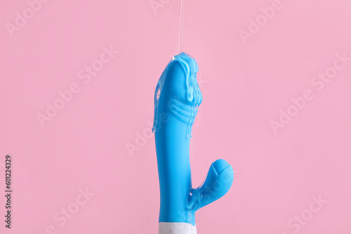 Vibrator with lubricant on pink background photo