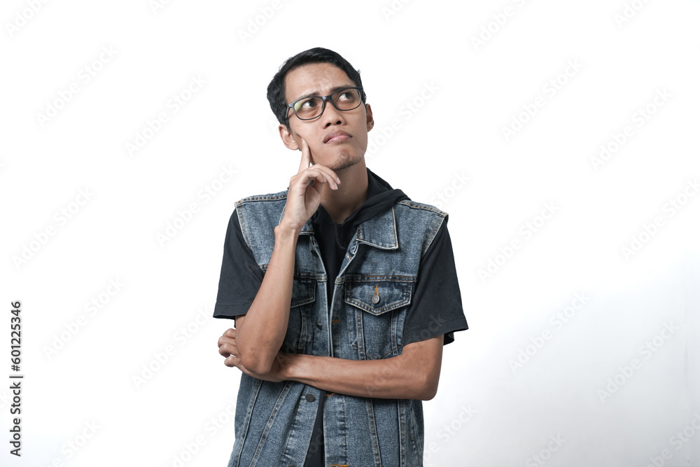 Asian man wearing sleeveless blue jean jacket, thinking gesture. Isolated white background Asian man wearing sleeveless blue jean jacket, thinking gesture. Isolated white background