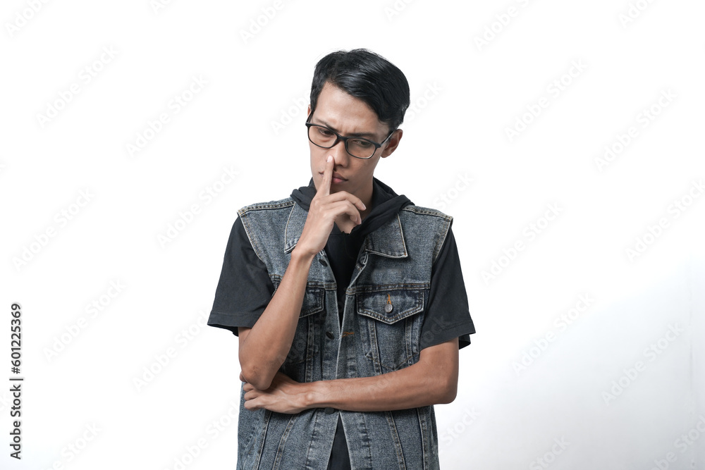 Asian man wearing sleeveless blue jean jacket, thinking gesture. Isolated white background Asian man wearing sleeveless blue jean jacket, thinking gesture. Isolated white background
