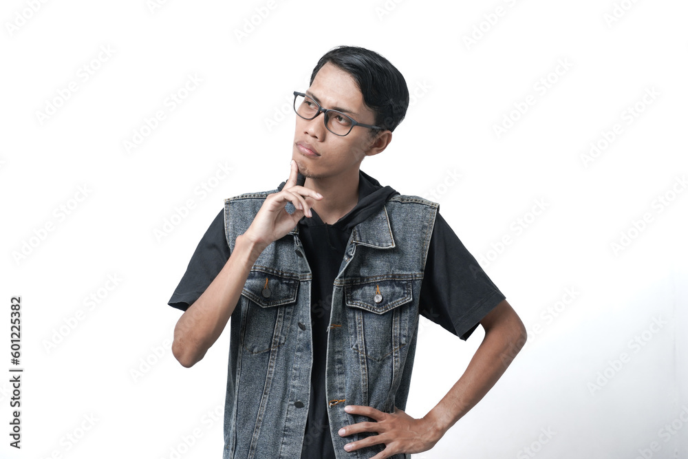 Asian man wearing sleeveless blue jean jacket, thinking gesture. Isolated white background Asian man wearing sleeveless blue jean jacket, thinking gesture. Isolated white background