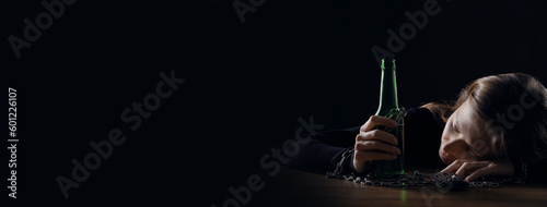 Suffering from hangover. Woman chained with bottle of beer sleeping at table against black background, space for text. Banner design