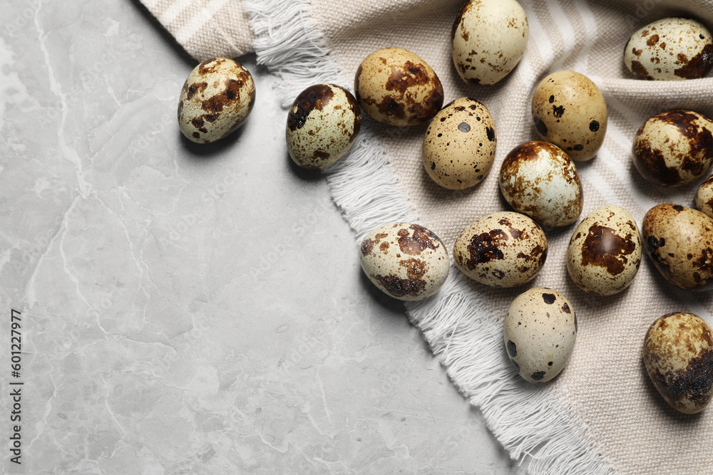 Many speckled quail eggs on light grey marble table, flat lay. Space for text Many speckled quail eggs on light grey marble table, flat lay. Space for text
