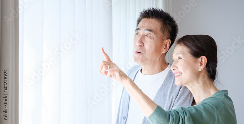 窓の外を眺めるシニア夫婦