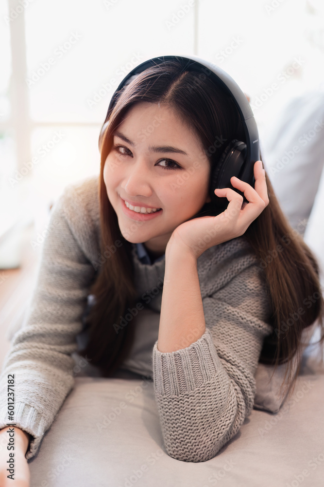 Online education, e-learning. Asian woman in stylish casual clothes, studying using a laptop, listening to online lecture, taking notes, online study at home Online education, e-learning. Asian woman in stylish casual clothes, studying using a laptop, listening to online lecture, taking notes, online study at home